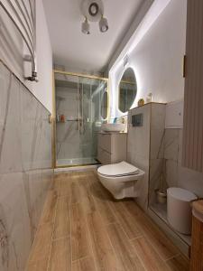 a bathroom with a toilet and a shower and a sink at Mieszkanie w centrum miasta in Kętrzyn +21 photos