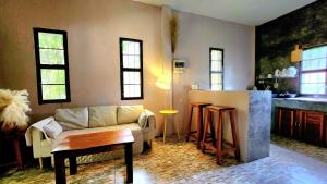 uma sala de estar com um sofá e uma cozinha em Phangan chai II by wildflower em Ko Phangan