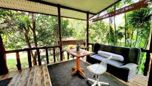 um alpendre com um sofá e uma mesa em Phangan chai II by wildflower em Ko Phangan