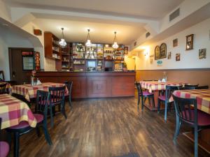 un restaurante con mesas y sillas y un bar en Sárga Csikó vendégház, en Debrecen