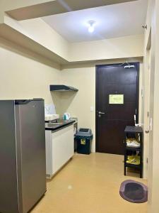 cocina con nevera y puerta negra en CDO cityscape CONDO, en Cagayan de Oro