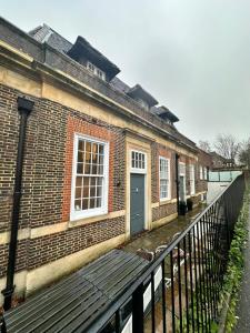 a brick building with a bench in front of it at Stunning 1 Bed Apartment - Perfect for Couples or Solo Stays in Tadworth +6 photos