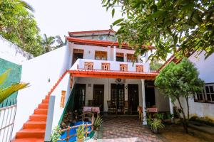 a white house with a red roof at Sanda Hiru Guest in Mirissa