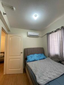 a small bedroom with a bed and a window at San Remo Oasis at City Di Mare in Cebu City