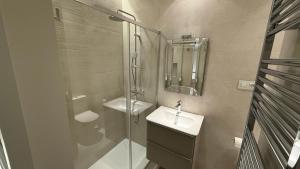 a bathroom with a glass shower and a sink at Stylish Haven in Chic Salamanca in Madrid