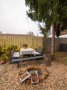 Una fogata en un patio trasero con una mesa y un árbol. en Sárga Csikó vendégház, en Debrecen