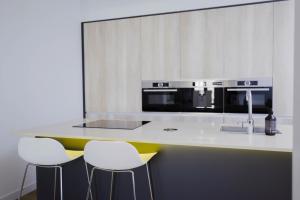 cocina con encimera con 2 taburetes y microondas en Wonderful 2BR2BA flat overlooking Pedro Zerolo S, en Madrid 20 fotos más