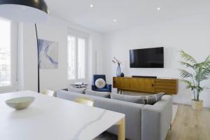 Una sala de estar con un sofá y un televisor. en Wonderful 2BR2BA flat overlooking Pedro Zerolo S, en Madrid