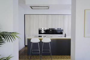 cocina con 2 taburetes y encimera en Wonderful 2BR2BA flat overlooking Pedro Zerolo S, en Madrid