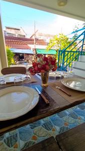 ein Tisch mit weißen Tellern auf einem Tisch in der Unterkunft Kata Lina guesthouse in Kata Beach