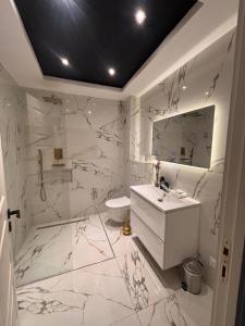 a white bathroom with a sink and a mirror at Appartement T3 in Frontenex-Villard-Rosset