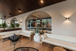 eine Lobby mit weißen Sofas sowie einem Tisch und Stühlen in der Unterkunft Ведмежа гора Panorama Spa Resort in Jaremtsche