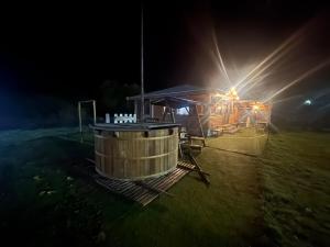 ZaseleЕлата的夜幕下的木屋，里面有个热水浴缸