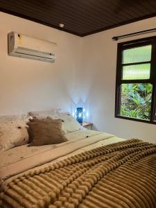 a bedroom with a large bed with a window at Pousada do Pescador in Florianópolis +86 photos