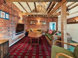 a living room with couches and a brick wall at 3 Bed in Edenbridge oc-o34127 in Hever