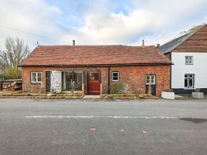 a brick house with a red door on a street at 3 Bed in Edenbridge oc-o34127 in Hever