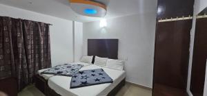 a small bedroom with a bed and a blue light at The Green Regency Annexe in Munnar