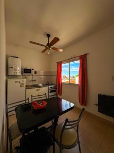 Apart hotel Bonato في La Porteña: مطبخ مع طاولة ومروحة سقف