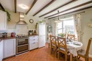 eine Küche mit einem Tisch und einem weißen Kühlschrank in der Unterkunft 3 Bed in Low Row oc-h34097 in Gunnerside + 21 Fotos