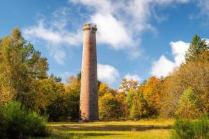 una torre de ladrillo alta en medio de un campo en S'Nekel Hisel - Gîte à Offwiller, 