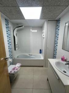 a bathroom with a bath tub and a sink at Playa Patacona vistas al mar in Valencia