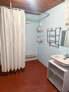 Un baño con una cortina de ducha blanca y un lavabo. en House in Finnish Lapland, en Kemijärvi
