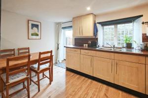 2 Bed in Eype oc-e34183 في ويست باي: مطبخ بدولاب خشبي وطاولة طعام +9 صور