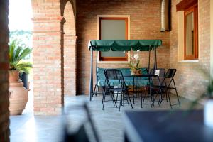 stół i krzesła pod zielonym parasolem na patio w obiekcie Agriturismo Dartora w mieście Sambruson