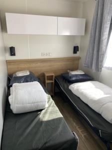 una stanza con due letti e una finestra di Camping Cristal d'Opale a Camiers