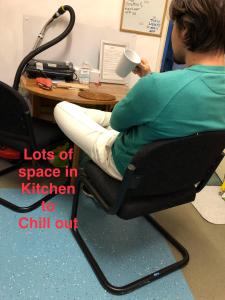 a man sitting in an office chair with a cup of coffee at quietSmall Box Room with window in Rotherham +2 photos