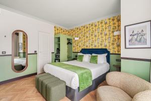 a bedroom with a large bed and two chairs at Hotel Du Flaneur in Paris