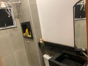 een badkamer met een spiegel en een toilet bij Vila das Orquídeas in Formosa