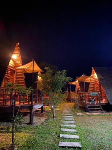 a group of wooden huts with umbrellas at night at Phu Aunna in Ko Phayam