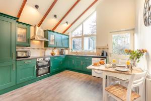 een keuken met groene kasten en een houten tafel bij 2 Bed in Norham oc-p34181 in Norham