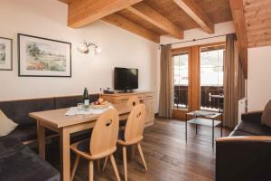 Una sala de estar con una mesa y un televisor. en Apartments in Serfaus - Ötztal 49987, en Serfaus
