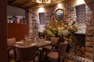 a dining room with a table and chairs and a brick wall at The George and Dragon - A Heartwood Inn in Marlow +28 photos