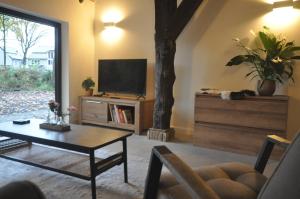 a living room with a table and a tv at Hoeve 't Peerdeke in Breda