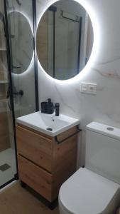 a bathroom with a toilet and a sink and a mirror at Bright Apartment AM in Bollullos par del Condado