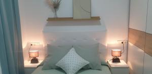 a bedroom with a bed with pillows and two lamps at Bright Apartment AM in Bollullos par del Condado