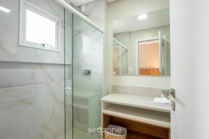 a bathroom with a glass shower and a sink at Apto c/ Churrasqueira a 500m da Praia TDF0302 in Itapema +16 photos