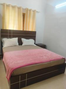 a bedroom with a bed with a pink blanket at Cadbury Pool Villa in Anachal