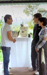 a group of people standing around a table with a machine at Café y sueños in Silvania +29 photos