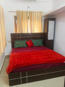 a bed with a red blanket and a window at Cadbury Pool Villa in Anachal