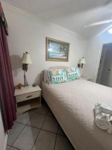 una piccola camera con letto e comodino con sidro di sidro. di Ocean View 2 Pools -Tennis ct - Shoreline Stays 22 a Galveston