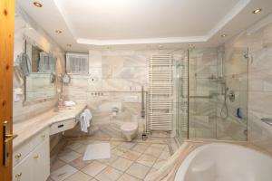 a bathroom with a tub and a shower and a toilet at Appartement Dachsteingasse by Schladming-Appartements in Schladming