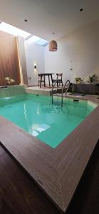 una piscina en una habitación con mesa en Nasma Chalet, en Barka