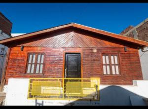 a small brick house with a black door at Hospedaje el Gorocito in Caleta Olivia