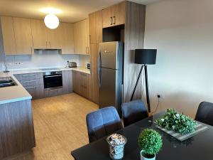 una cucina con tavolo e frigorifero di ANTHEMIs COTTAGE RED a Kyperounda Altre 28 foto