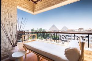 a balcony with a bench and a view of the pyramids at Cozy vintage duplex Khan -khan luxe residence pyramids view in Cairo +89 photos