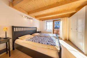 Un dormitorio con una cama grande con techo de madera. en Haus Alpenruhe, en Königsleiten